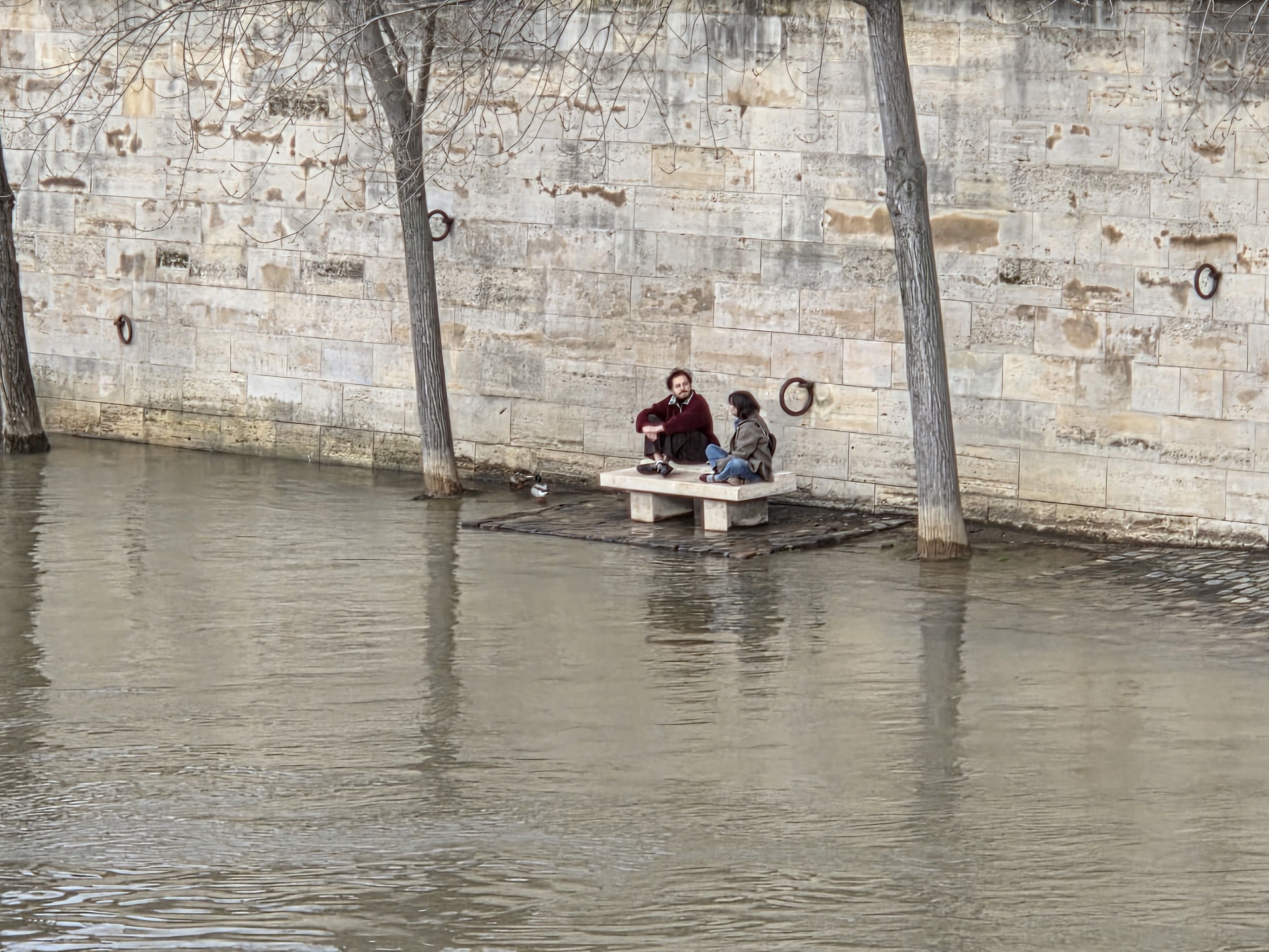 Couple sitting next to Seine